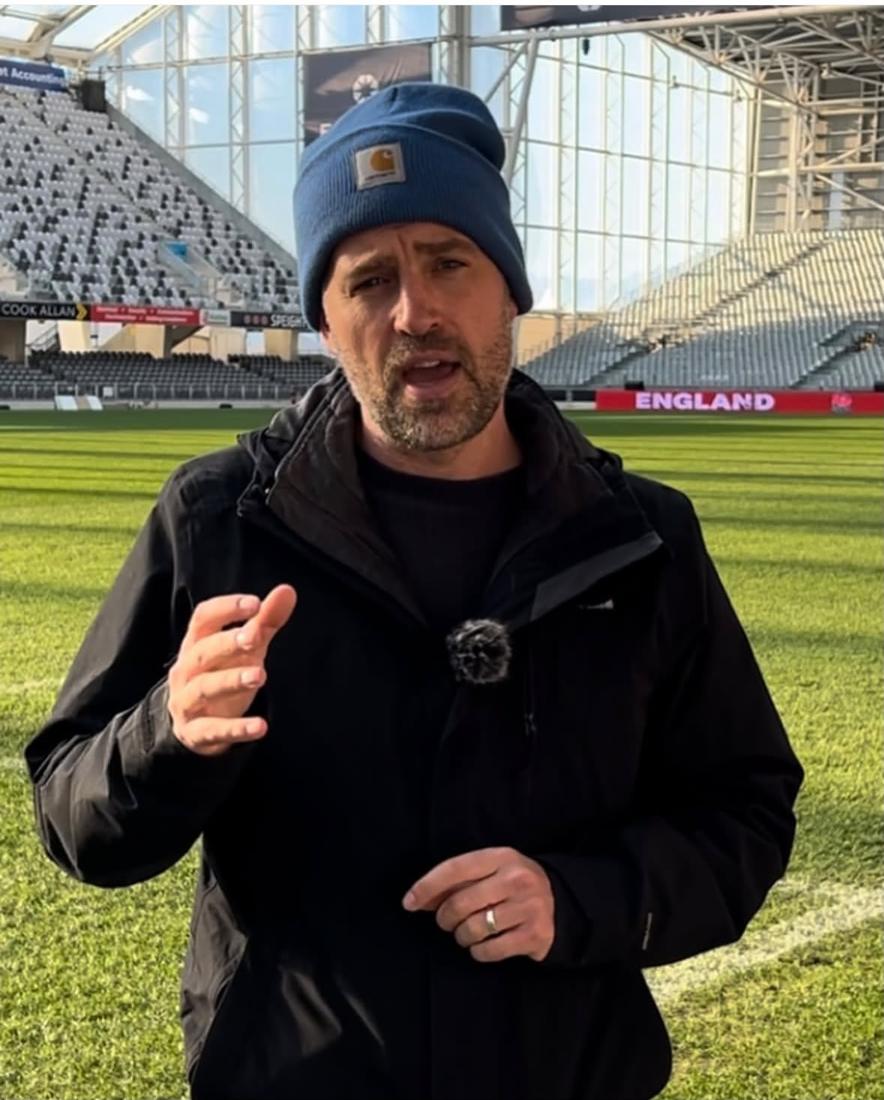 Chris reporting pitchside inside a stadium on tour