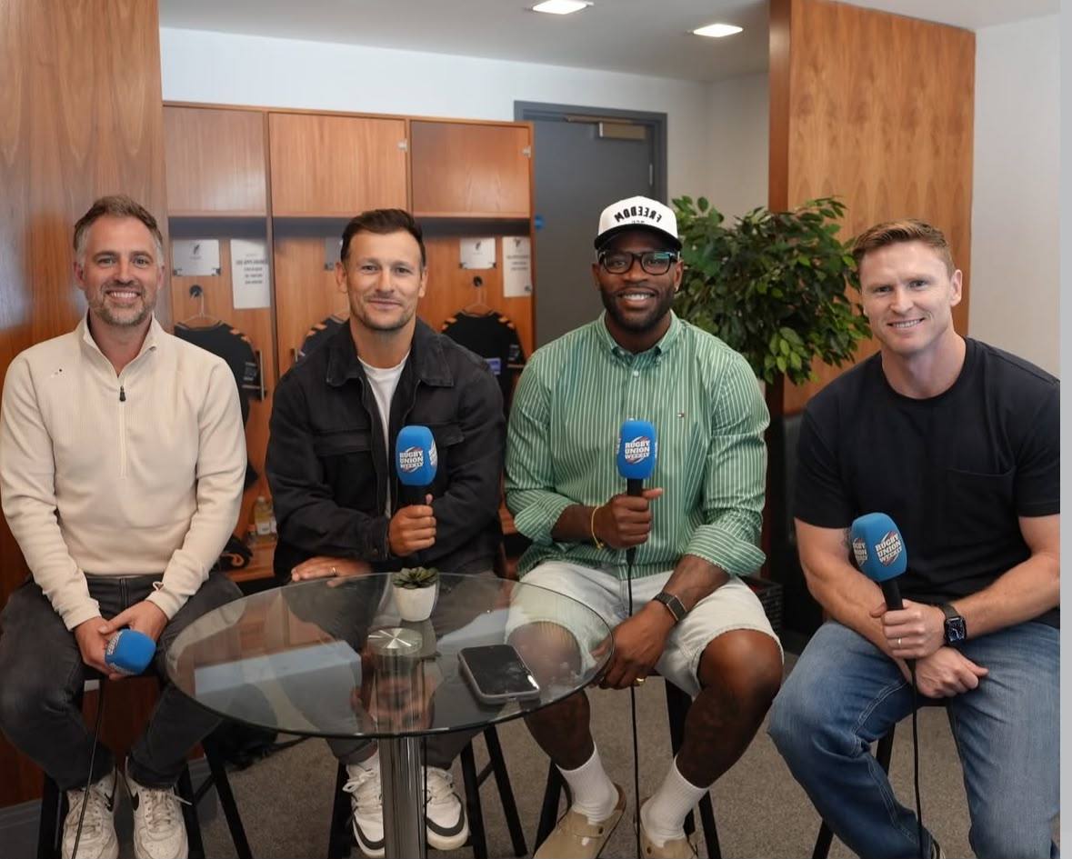 The four Rugby Union Weekly hosts with 5 Live microphones in a changing room